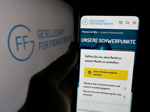 Stuttgart, Germany - 10-24-2024: Person holding smartphone with webpage of Gesellschaft f&uuml;r Freiheitsrechte e.V. (GFF) on screen with logo. Focus on center of phone display.
