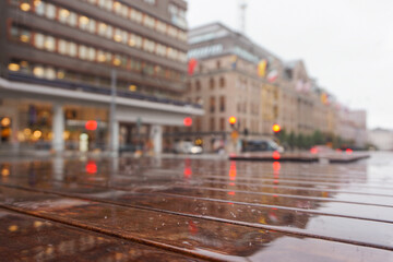 Close up of a wet wooden bench in city