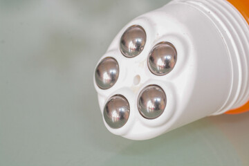 The image shows a close-up of a massage tool with multiple metal rollers.