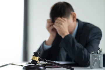 A lawyer is stressed while sitting at a desk at a law firm giving the appearance