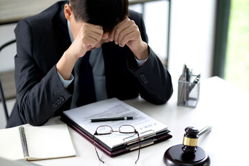 A lawyer is stressed while sitting at a desk at a law firm giving the appearance
