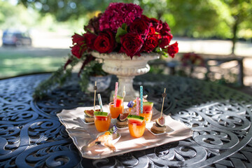Elegant Outdoor Appetizers with Floral Centerpiece on Iron Table