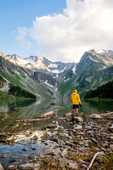 a photographer on the shore of the Multin lake in a yellow jacket. Altai. Siberia. Amazing view