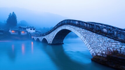 Obraz premium Tranquil Old Stone Bridge in Misty Village Landscape
