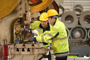 two professional engineer, worker, technician use clipboard discuss work, walk in steel metal manufacture factory plant industry. Asian man and woman wear hard hat check quality machine