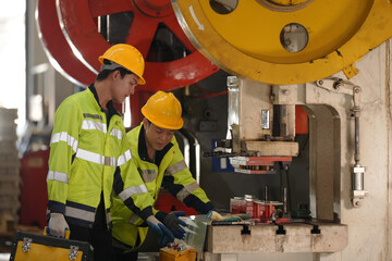 two professional engineer, worker, technician use clipboard discuss work, walk in steel metal manufacture factory plant industry. Asian man and woman wear hard hat check quality machine