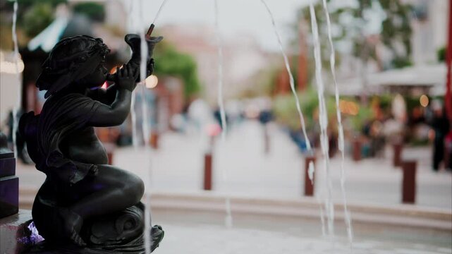 Close up of a water pouring in a fountain with a blurry background in Cannes, France