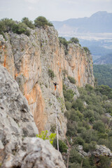 A tightrope walker walks along a cable stretched over a canyon.