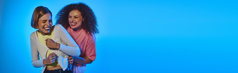 A joyful couple showcases love and diversity against a colorful studio backdrop, embracing each...