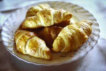 Stack of fresh croissants arranged on plate for breakfast