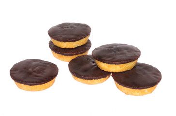 Six small cakes with chocolate glazing isolated on a white background.