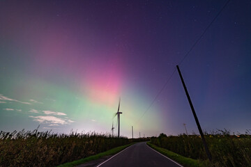 turbine at night with an aurora glow
