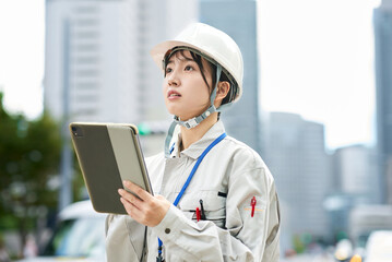 作業服とヘルメットを着用した若い女性