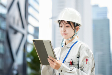 作業服とヘルメットを着用した若い女性