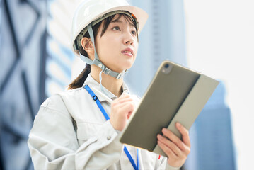 作業服とヘルメットを着用した若い女性