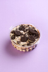 white chocolate cake with biscuit seen from the side on a lilac background