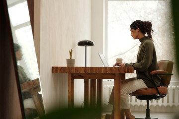 Architect sitting at desk with laptop, concentrated on work