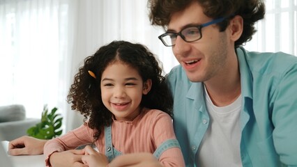 Father explain generate AI while american girl looking at screen. Attractive caucasian dad teaching...