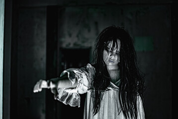 female ghost with a face full of hatred and horror wearing a white dress in a haunted room