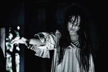 female ghost with a face full of hatred and horror wearing a white dress in a haunted room