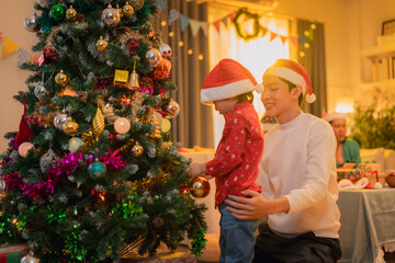 A joyful family celebration around Christmas tree, featuring man and child wearing Santa hats. festive atmosphere is enhanced by colorful decorations and warm lighting