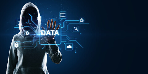 Hacker in hoodie using glowing data hologram on blue background with mock up place. Big data,...