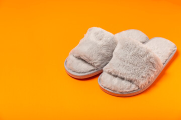 Soft slippers on a bright colored background, close-up. House slippers. Comfortable shoes for home. Foot care concept. Home comfort. Space for text. Copy space.