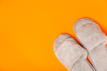 Soft slippers on a bright colored background, close-up. House slippers. Comfortable shoes for home. Foot care concept. Home comfort. Space for text. Copy space.