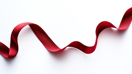 Elegant red ribbon twisting gracefully on a white background.