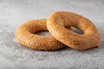 Traditional turkish simit sesame bagels  on wooden board on stone table background.