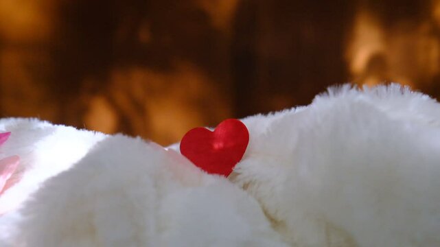 Red heart on  soft blanket, cozy home and lazy holidays. White wall with dancing shadow and place for text. Valentines Day, Wedding, Dating, Love