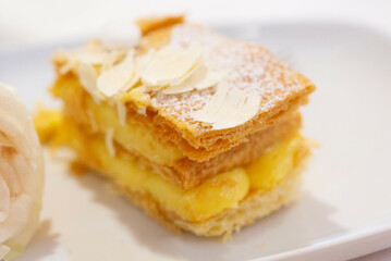 A piece of millefeuille cake on a plate. Close-up