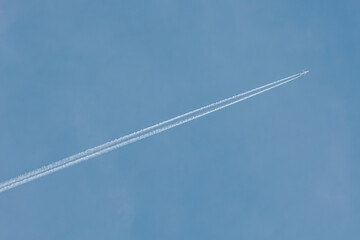 A jet airplane flying at high altitude, leaving a clean, straight contrail across the clear blue sky. The minimalist scene evokes freedom and simplicity in open airspace.