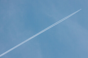 A jet airplane flying at high altitude, leaving a clean, straight contrail across the clear blue sky. The minimalist scene evokes freedom and simplicity in open airspace.