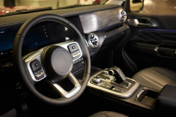 Closeup of a modern car steering wheel with control buttons for technology and convenience