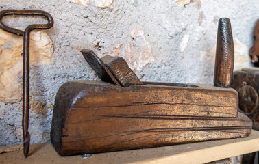 A vintage woodworking planer made out of wood and a bradawl on a self.