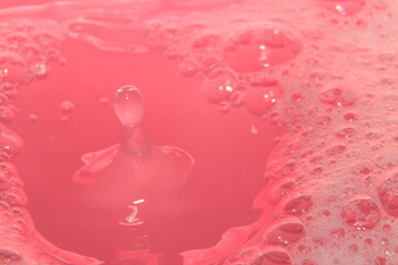 water dropping in pink soap bubbles