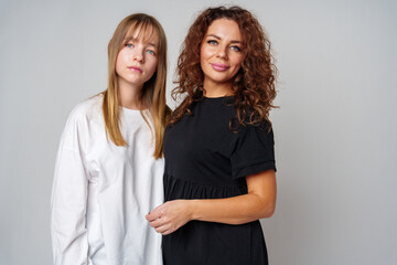 Two women standing together, one in white and the other in black, showcasing a warm connection