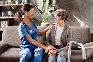 Support and care. Trustful and confident caregiver helping aiding senior patient with movements,...
