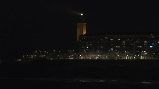 Night view of Riazor beach in A Coru&ntilde;a and the Hercules Tower lighthouse shining