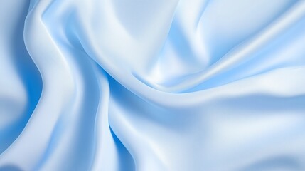 Obraz premium Soft blue satin fabric draping gracefully on a surface, showcasing delicate textures and folds in natural light