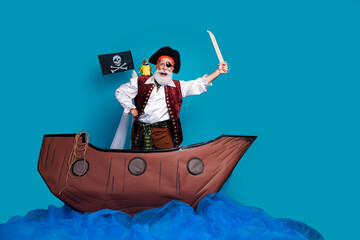 Photo of crazy man wear pirate traditional costume swimming on wooden boat isolated on blue color...
