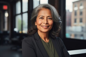 Smiling portrait of a senior Indian businesswoman in modern office