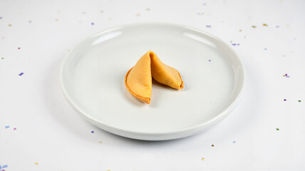 Fortune cookie on white plate, simple celebration setting