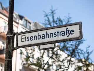Eisenbahnstrasse street name sign in Berlin, Germany. Road signage at the intersection. Close up of the location guide showing the direction of the street.