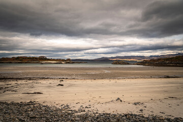 A cloudy, autumnal HDR image of an empty Samalaman Bay with Samalaman Island in the background, Glenuig, Moidart, Lochaber, Scotland.