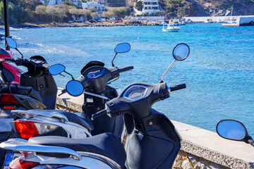 Motorcycles parking at Kalymnos beach, Greece. Coast and blue Aegean Sea