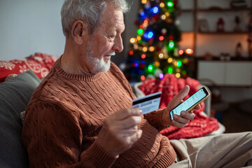 Senior man shopping online with credit card during Christmas holidays