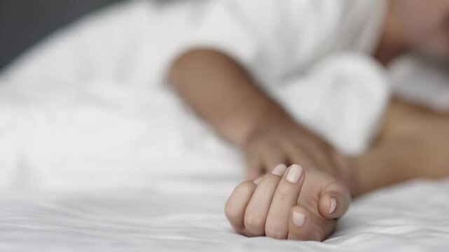 Sensual couple in bed enjoying privacy with each other. Focus on the hands of the man and woman.