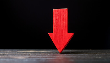 Red wooden arrow pointing down on black background. Business, market decline or economic